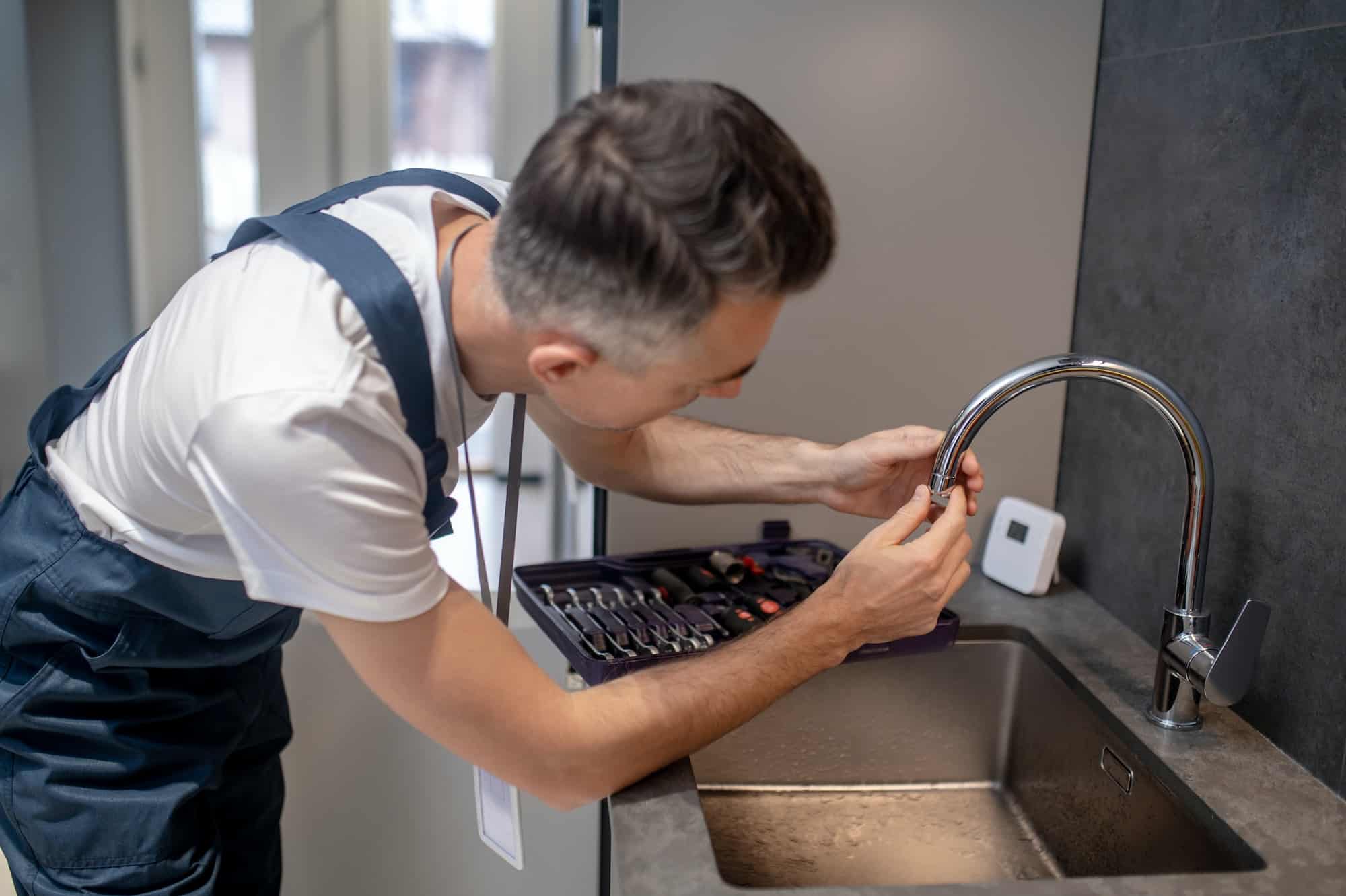 man-spinning-faucet-aerator-on-spout-pipe.jpg